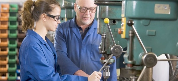Tutor de empresa supervisando y tutorizando a una trabajadora en contrato para la formación y el aprendizaje